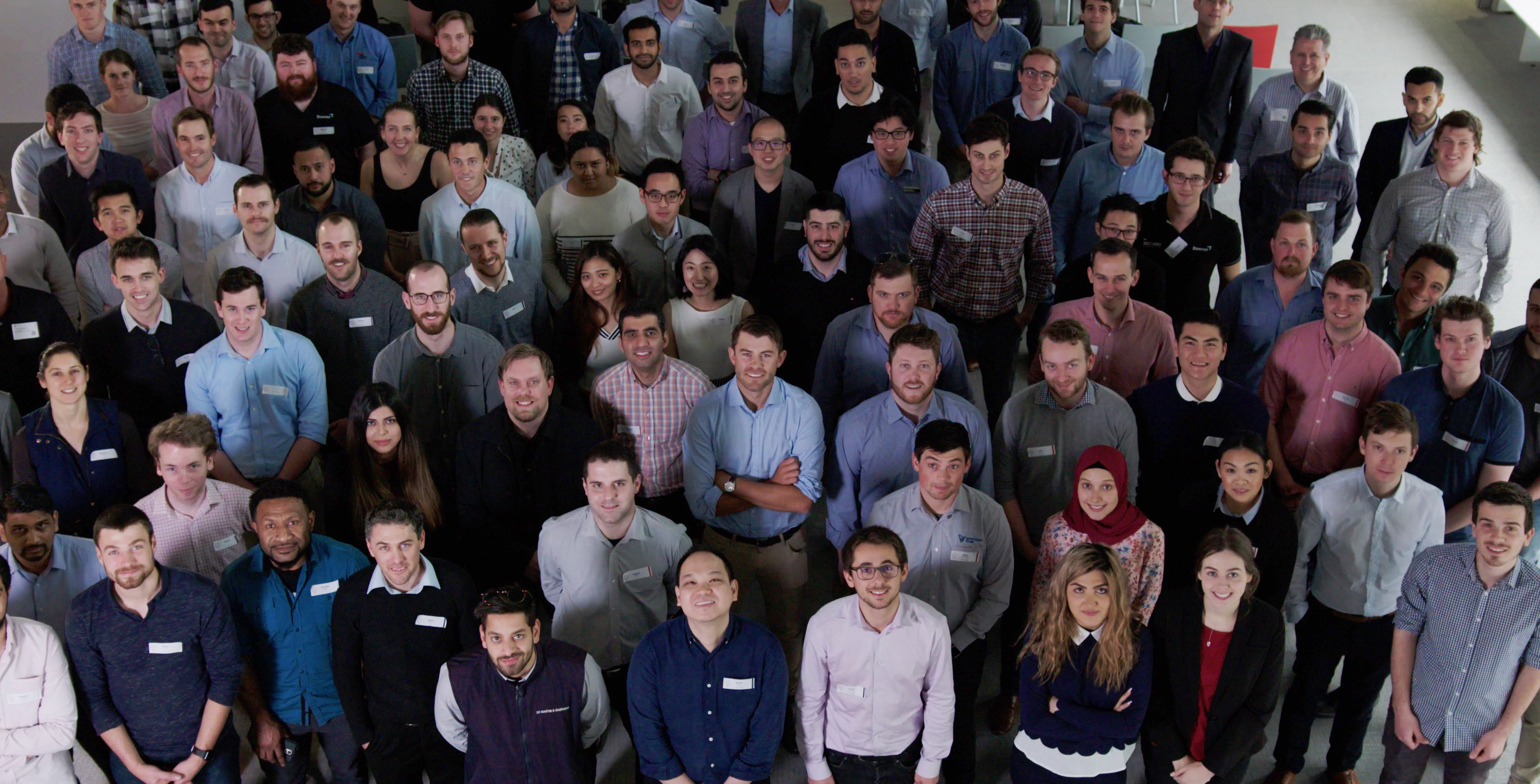 Large group of young professionals looking up to camera