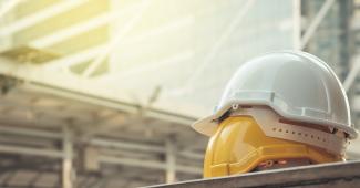 Two stacked hard hats in front of construction building