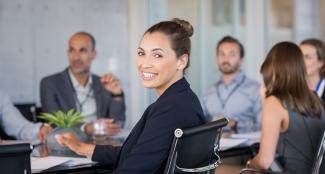 Proud smiling business woman sitting during a meeting and looking at camera