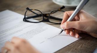 Hand signing a paper contract