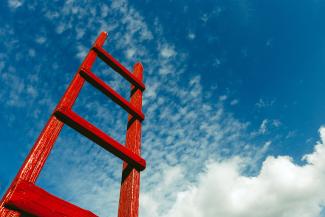 Red ladder against blue sky