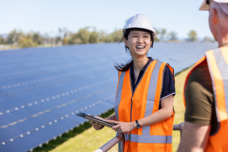 Female Chinese-Australian Engineer And Senior Caucasian Male Engineer Working Together On Solar Farm Installation